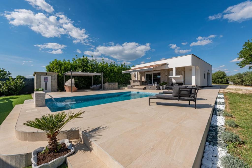 a backyard with a swimming pool and a villa at Kuća za odmor Dora in Benkovac