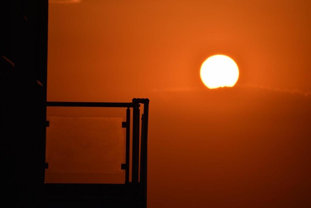 um pôr do sol no céu sobre um edifício em MG Villas & Suites em PalaiónTsiflíkion