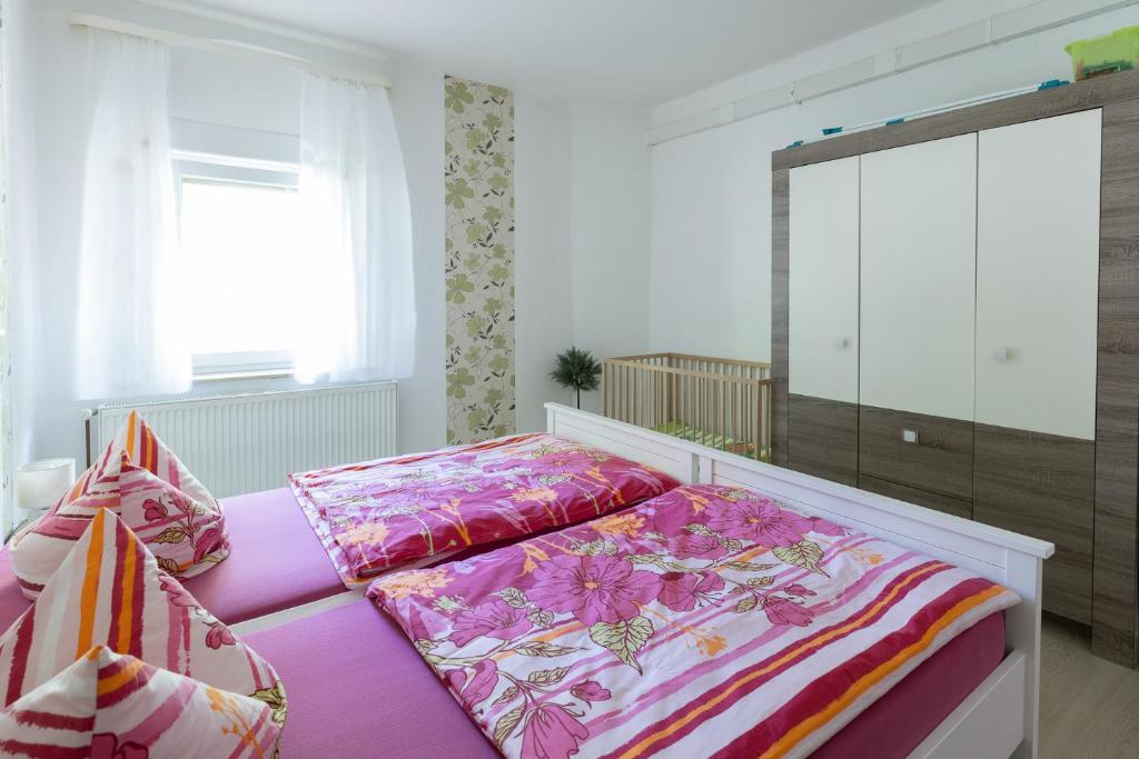 1 dormitorio con 1 cama con sábanas rosas en Ferienwohnung Baatz en Lehnin