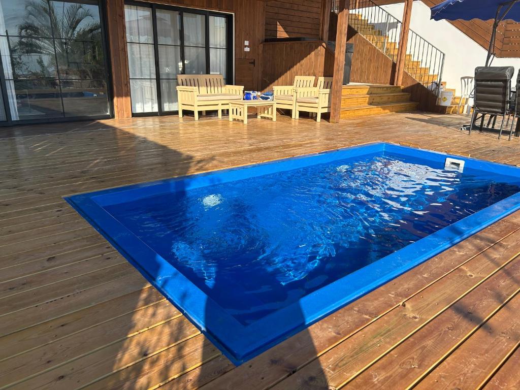 una piscina de fibra de vidrio azul en una terraza de madera en מבית תכלת בית של חופש Allentown 21 אלנטאון 21 en Tiberias