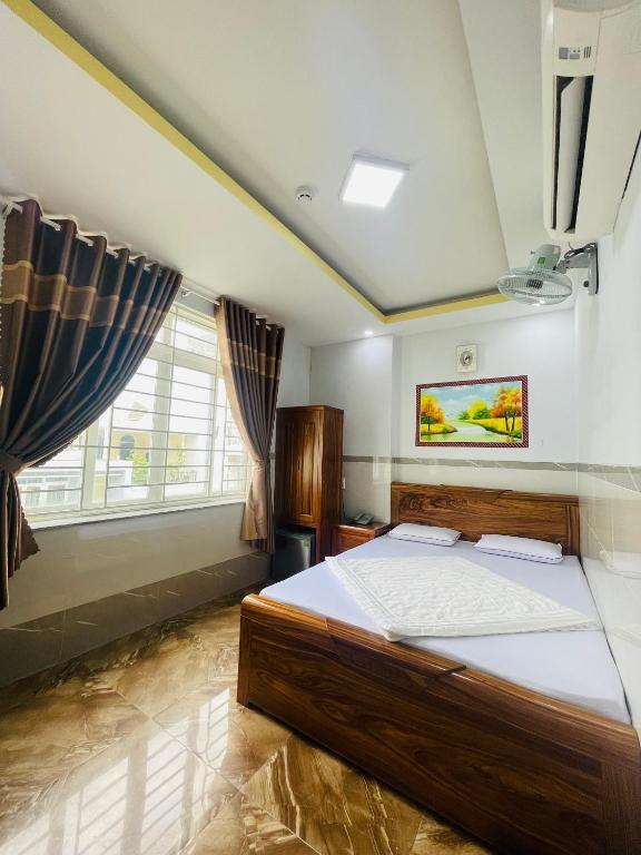 Khách sạn THUỲ DƯƠNG 1 في مدينة هوشي منه: غرفة نوم بسرير كبير ونافذة