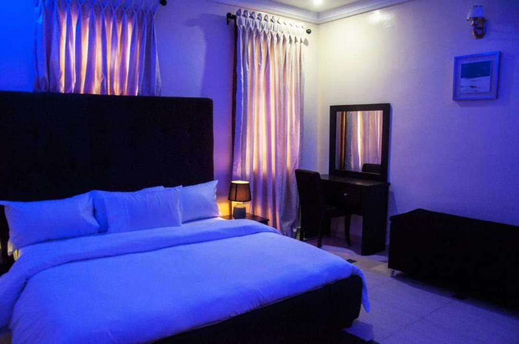 a bedroom with a bed and a desk and a mirror at BTT Homes in Lekki