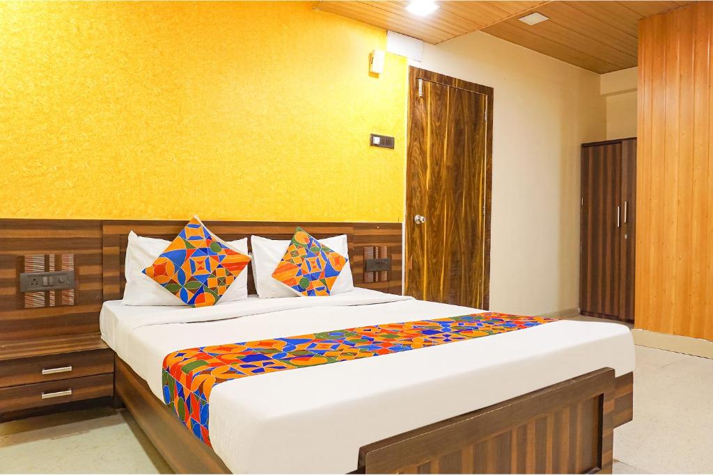 a bedroom with a large bed with colorful pillows at FabExpress Gargi Executive in Pune