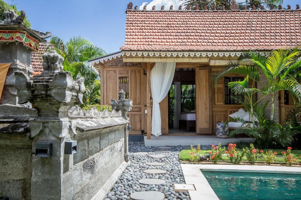 een huis met een zwembad en een huis bij Nido Boutique Cottage by BaliSuperHost in Canggu