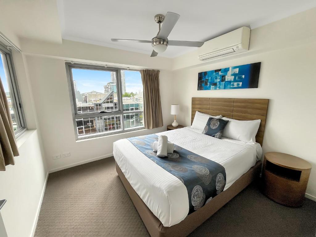 een slaapkamer met een groot bed en een groot raam bij Direct Collective - Pavilion and Governor on Brookes in Brisbane
