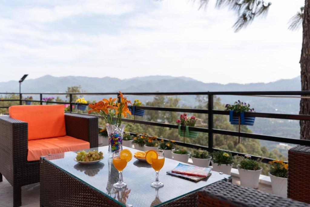 a patio with a table and chairs with a view at Villa Woodside Meadows by VEO - 3BR with Comp BF, Glasshouse 360 View of Kasauli in Kasauli