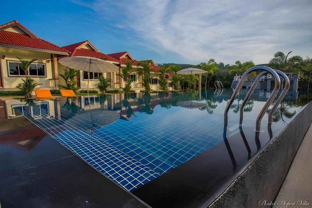 a swimming pool at a villa with a resort at Phuket Airport Villa in Phuket Town