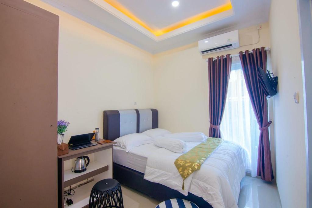 a small bedroom with a bed and a window at RedDoorz syariah near Universitas Islam Riau in Pekanbaru