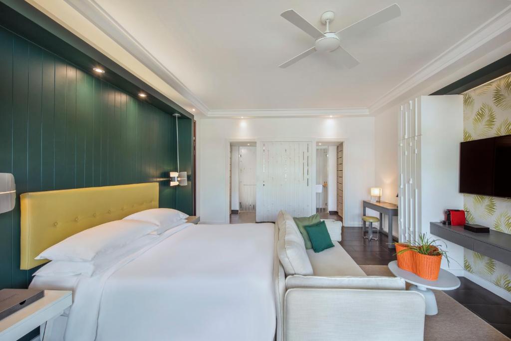 una camera con un grande letto e un divano di Long Beach Mauritius a Belle Mare