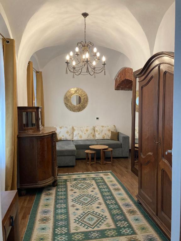 a living room with a couch and a chandelier at Old Town Sibiu Studio - Historical Center Residence in Sibiu