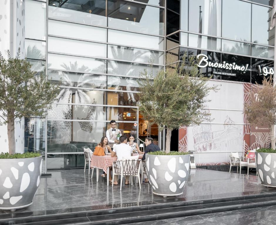 a group of people sitting at a table outside a building at Golden Sands Boutique Hotel-Dubai Creek in Dubai