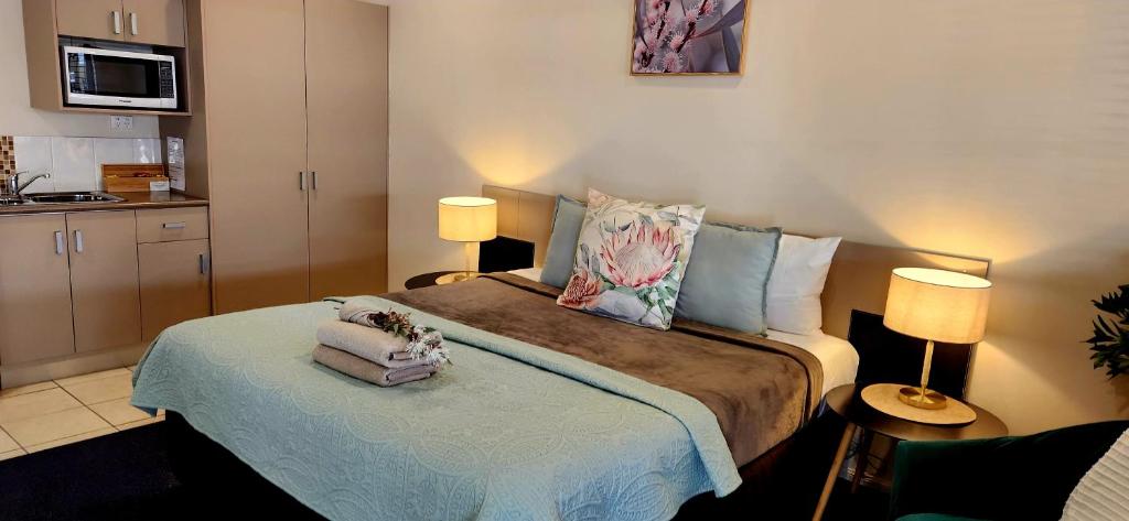 sypialnia z łóżkiem i 2 lampami oraz kuchnia w obiekcie Charters Towers Motel w mieście Charters Towers