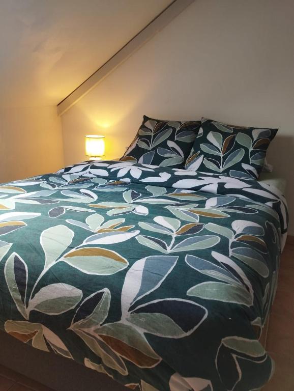 a bedroom with a bed with a green and white comforter at CASA COLIVING avec chambre salle de bain individuelles privatives in Saint-Pierre