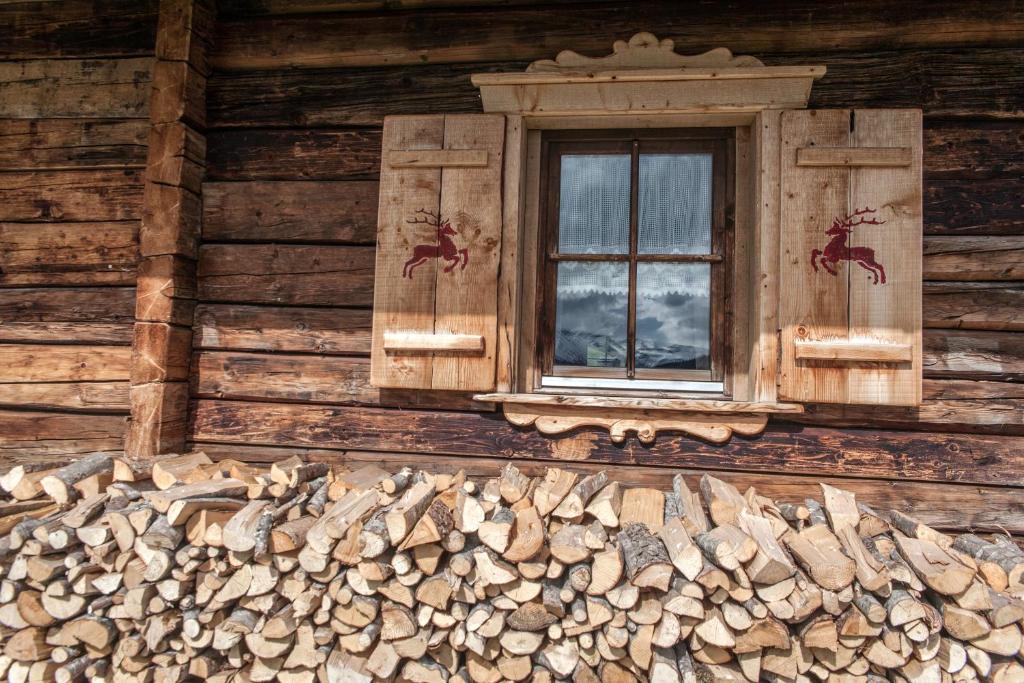 una finestra sul lato di una baita di tronchi di Alpengasthof Karalm a Rauris