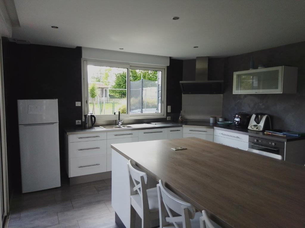 - une cuisine avec une table en bois et un comptoir dans l'établissement Maison 15 min du Mont St Michel, à Saint-James