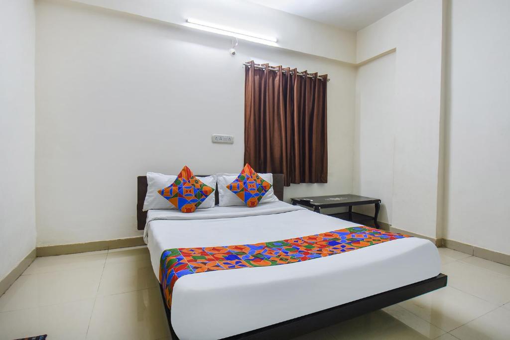 a bedroom with a large bed with colorful sheets at FabExpress Shri Krishna in Pune