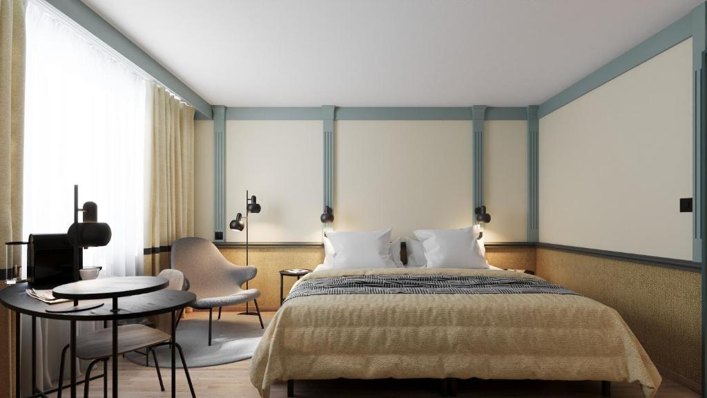 Schlafzimmer mit einem Bett, einem Tisch und Stühlen in der Unterkunft Hotel Luzernerhof in Luzern