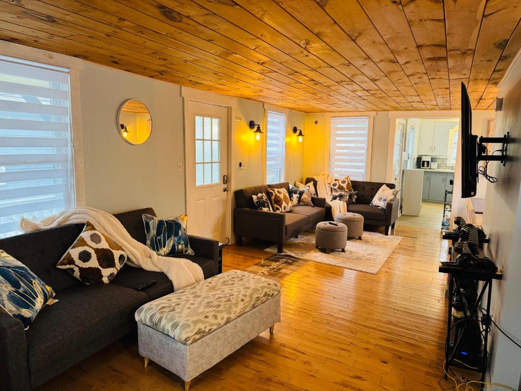 un soggiorno con divani e soffitto in legno di Lovely Old Orchard Beach Home a Old Orchard Beach