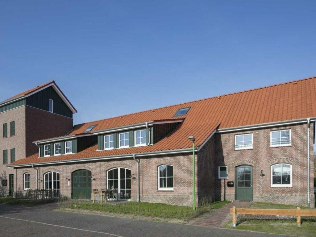un grand bâtiment en briques avec un toit rouge dans l'établissement Old fire department Feuerperle No 4HR, à Langeoog