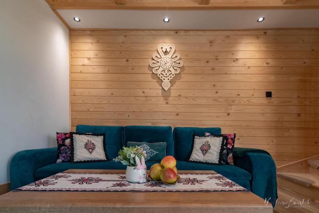 a blue couch with a table and fruit on it at Domek u Hanci z jacuzzi in Zakopane