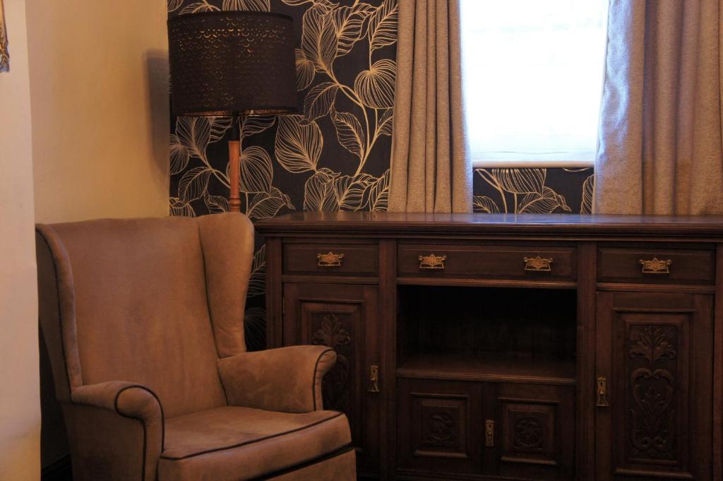una silla junto a una cómoda y una ventana en Star Inn Hotel, en Upton upon Severn