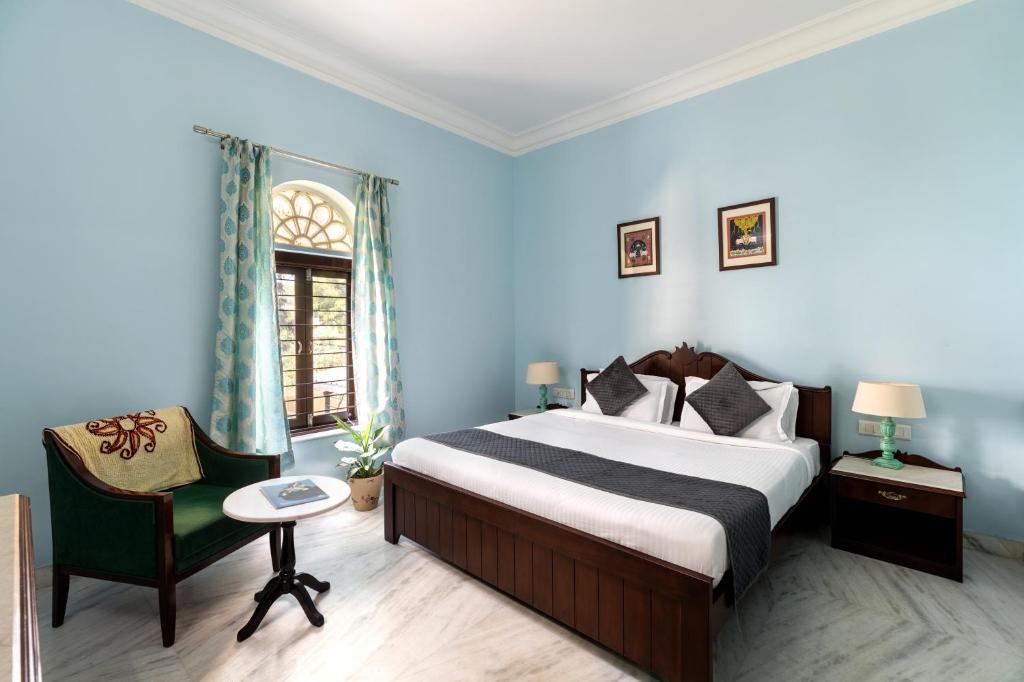 a hotel room with a bed and a chair at Chandra Vilas Heritage stay in Udaipur