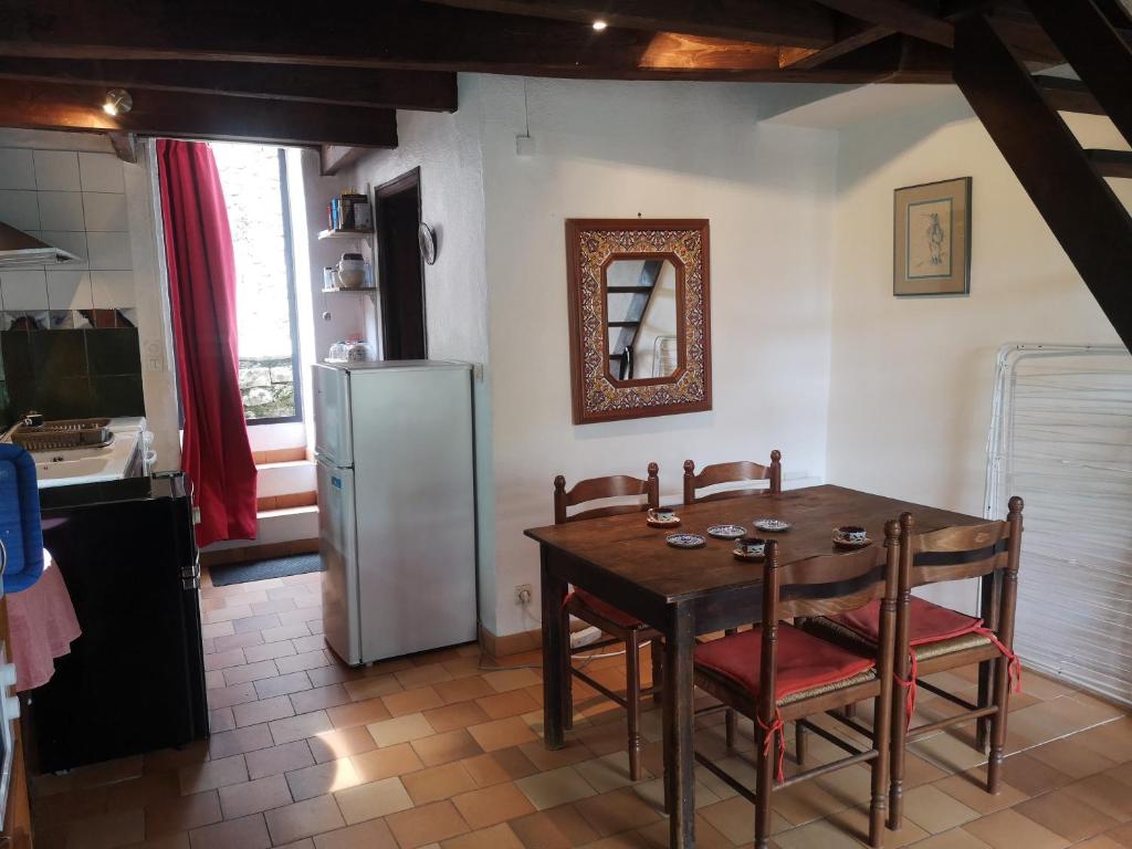 une cuisine avec une table et un réfrigérateur dans l'établissement Maison Casal, à Campestre-et-Luc