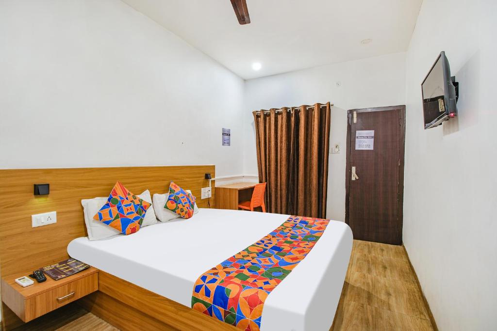 pokój hotelowy z łóżkiem i telewizorem w obiekcie FabExpress Anurag Residency w mieście Guwahati