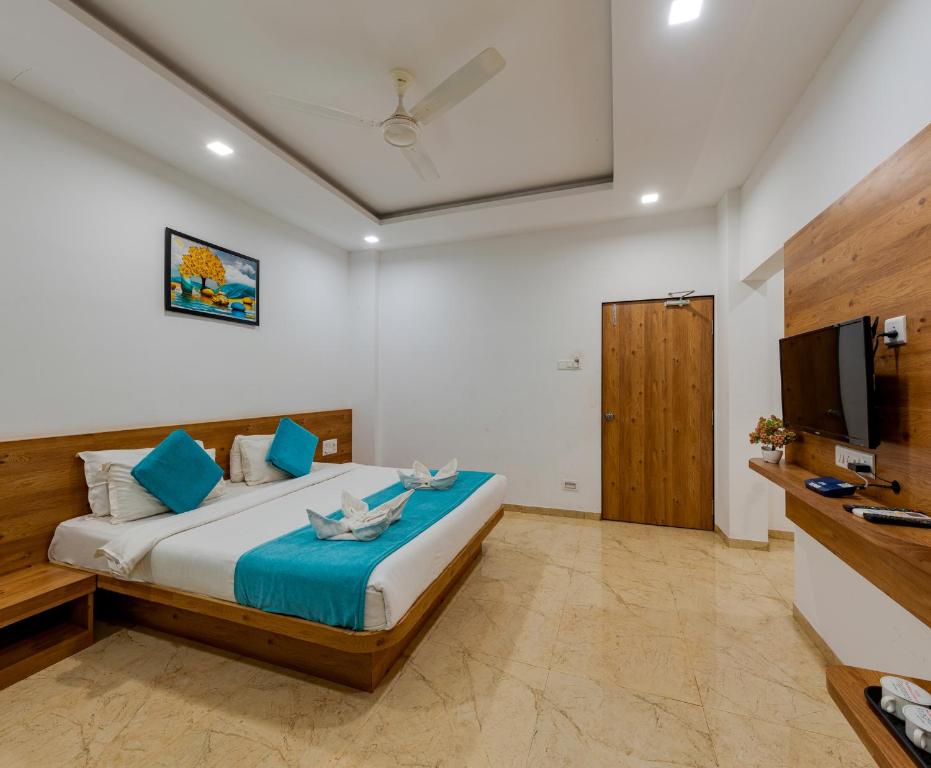 Schlafzimmer mit einem Bett und einem Flachbild-TV in der Unterkunft Hotel Mahabaleshwar Fragrance in Mahabaleshwar