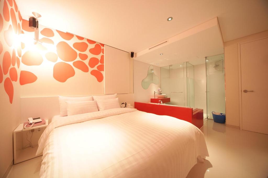 a bedroom with a large white bed and a mirror at Jongno Hotel Pop Leeds Premier in Seoul