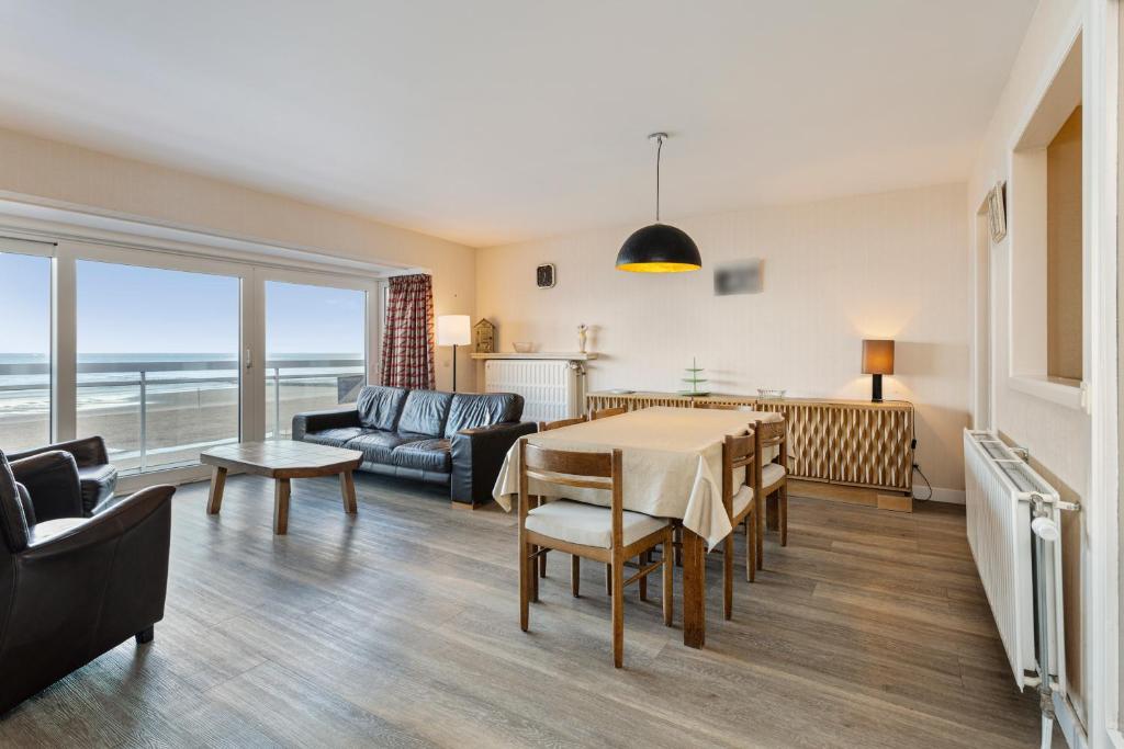 een woonkamer met een tafel en een bank bij Makapi 3v in Wenduine