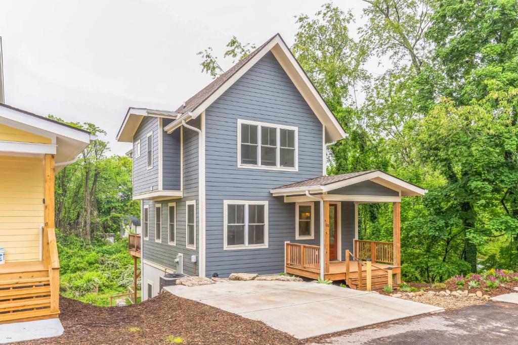 une maison bleue avec une terrasse couverte et une terrasse dans l'établissement Asheville NC-30 day stays only- home, à Asheville