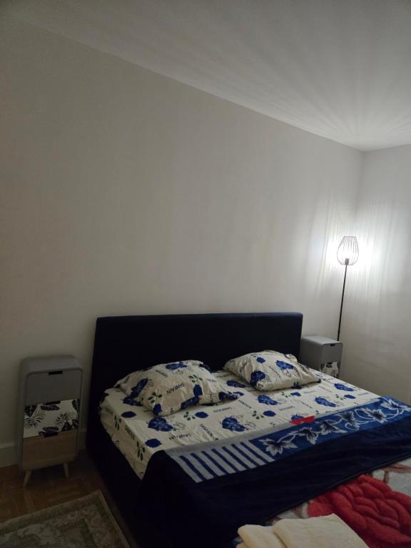 une chambre avec un lit avec une couette bleue dans l'établissement Appartement T3 tout confort, à Sartrouville