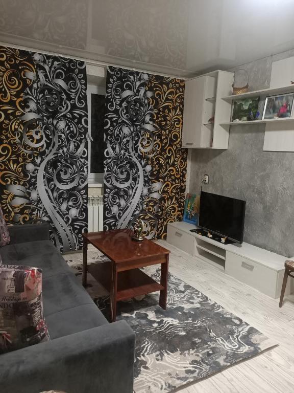 タラズにあるОднокомнатная квартира Люкс в центре.のソファとテレビのあるリビングルーム