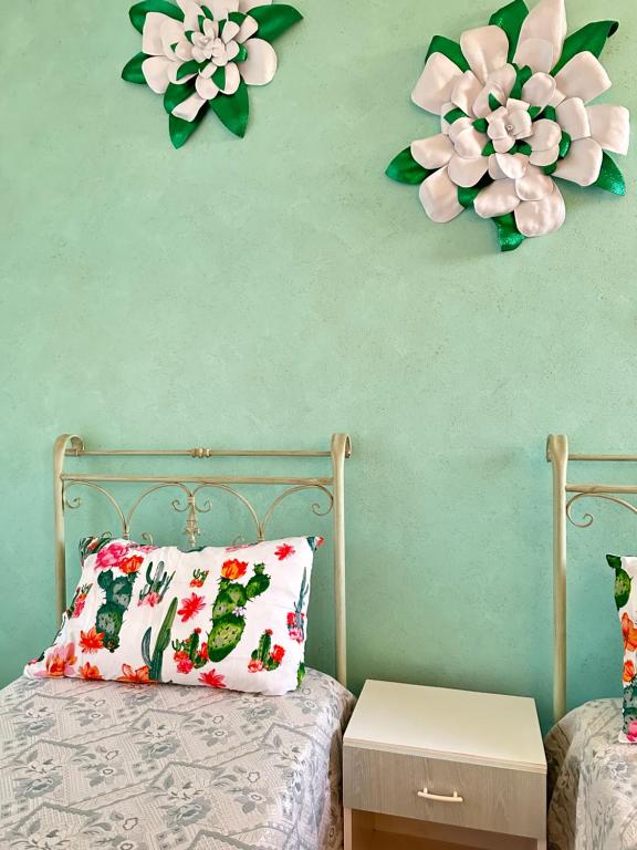 una camera da letto con due fiori di carta sul muro di Fiori e Farfalle - Casa Vacanze a Scorrano