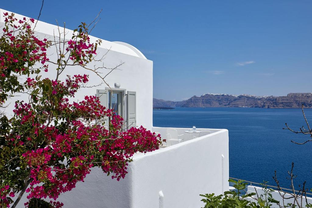 a white building with a view of the water at Santorini View in Akrotiri