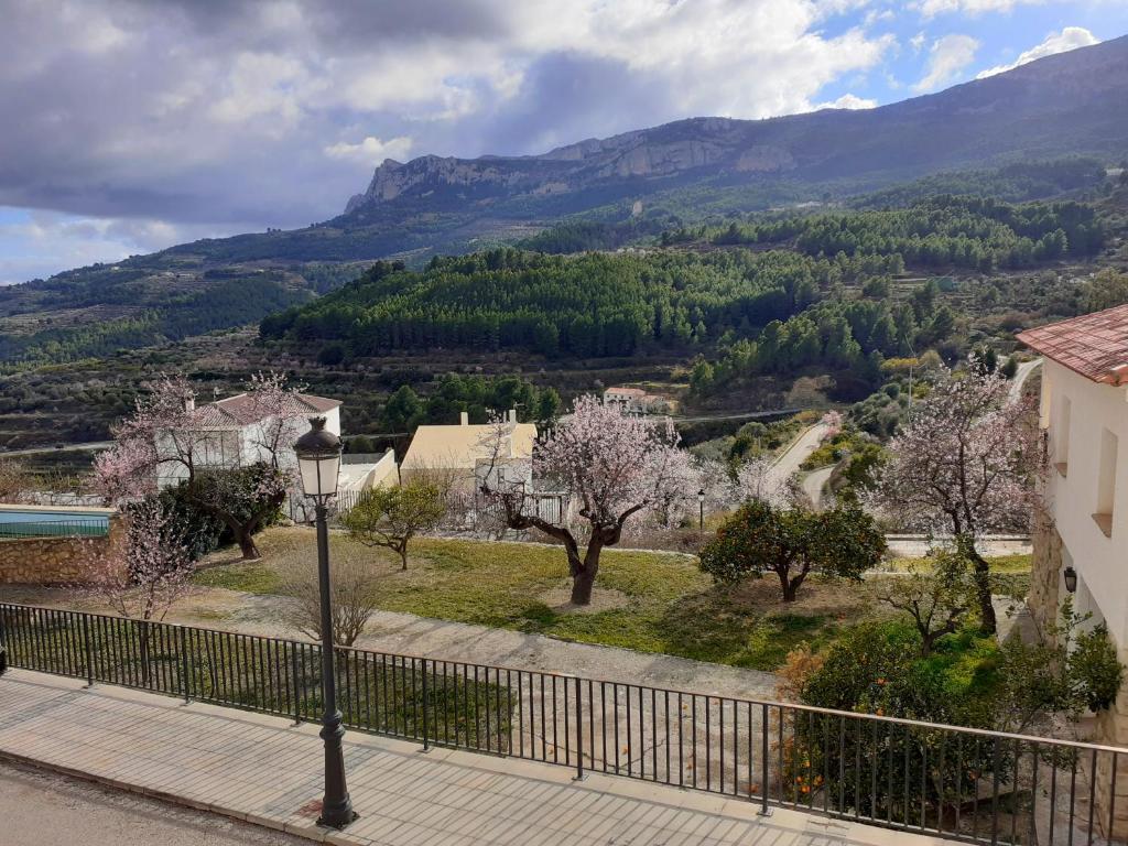 a street light on a sidewalk with trees and mountains at Guadalest Panorama in Guadalest