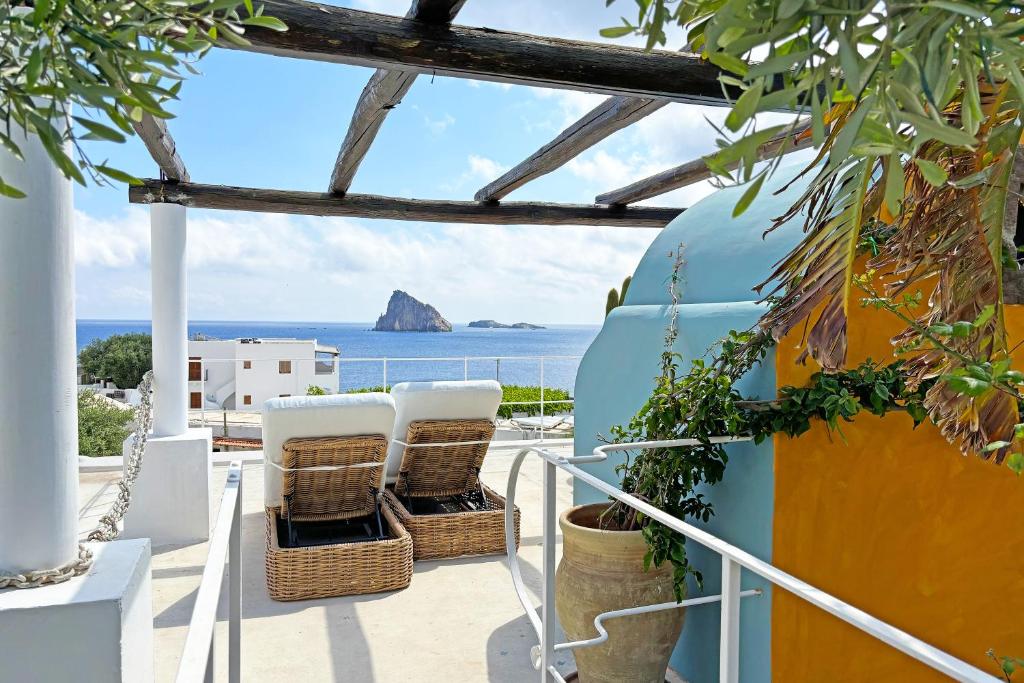 een balkon met stoelen en de oceaan op de achtergrond bij Casa Ambra in Panarea