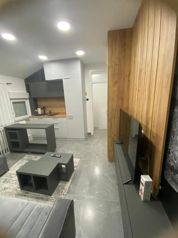 ein Wohnzimmer mit einem Sofa und einer Küche in der Unterkunft apartman HAJLA in Rožaje
