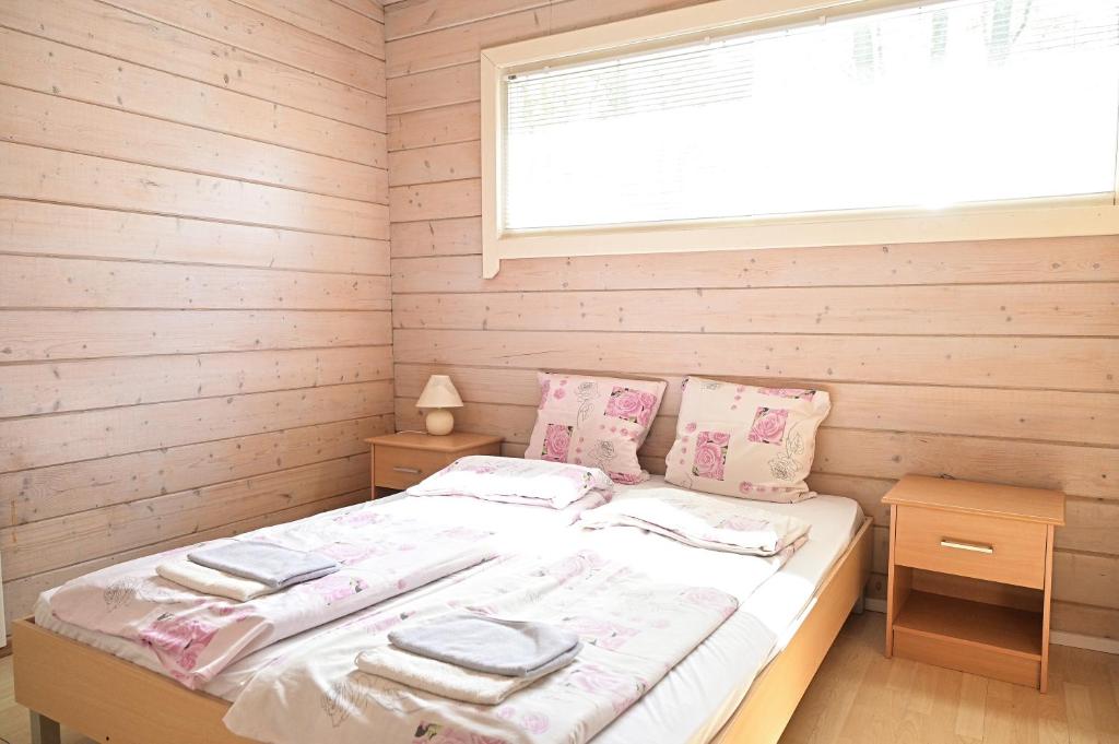 クライペダにあるGirulių poilsiavietės namelis - IXの窓のある木製の壁のドミトリールームのベッド1台分です。
