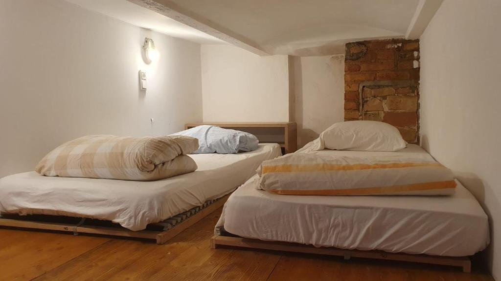 2 camas individuales en una habitación con una pared de ladrillo en Freiraum Hostel Kreuzberg, en Berlín