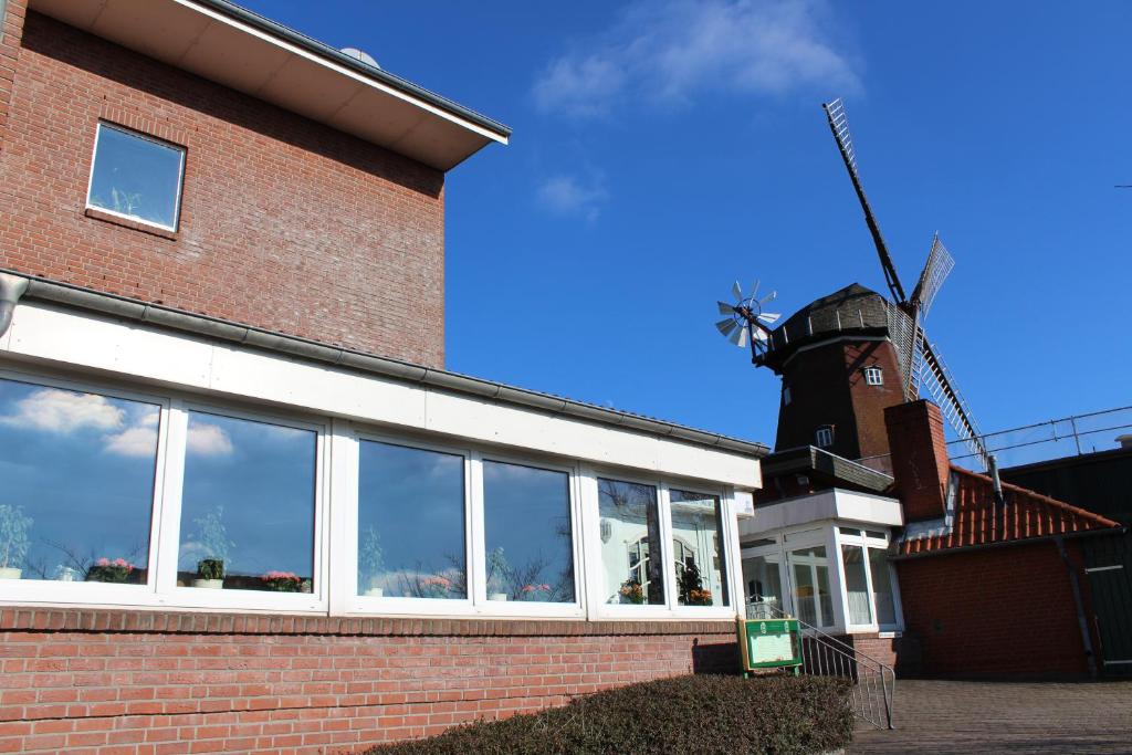 een bakstenen gebouw met een windmolen op de achtergrond bij Lauenburger Mühle in Lauenburg