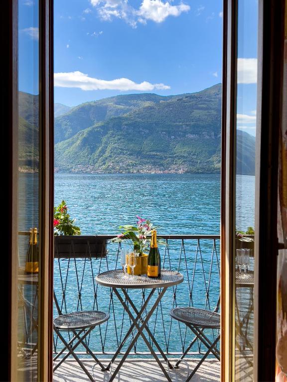 a table on a balcony with a view of the water at Appartamento Try on Lake Como with Balcony in Lezzeno