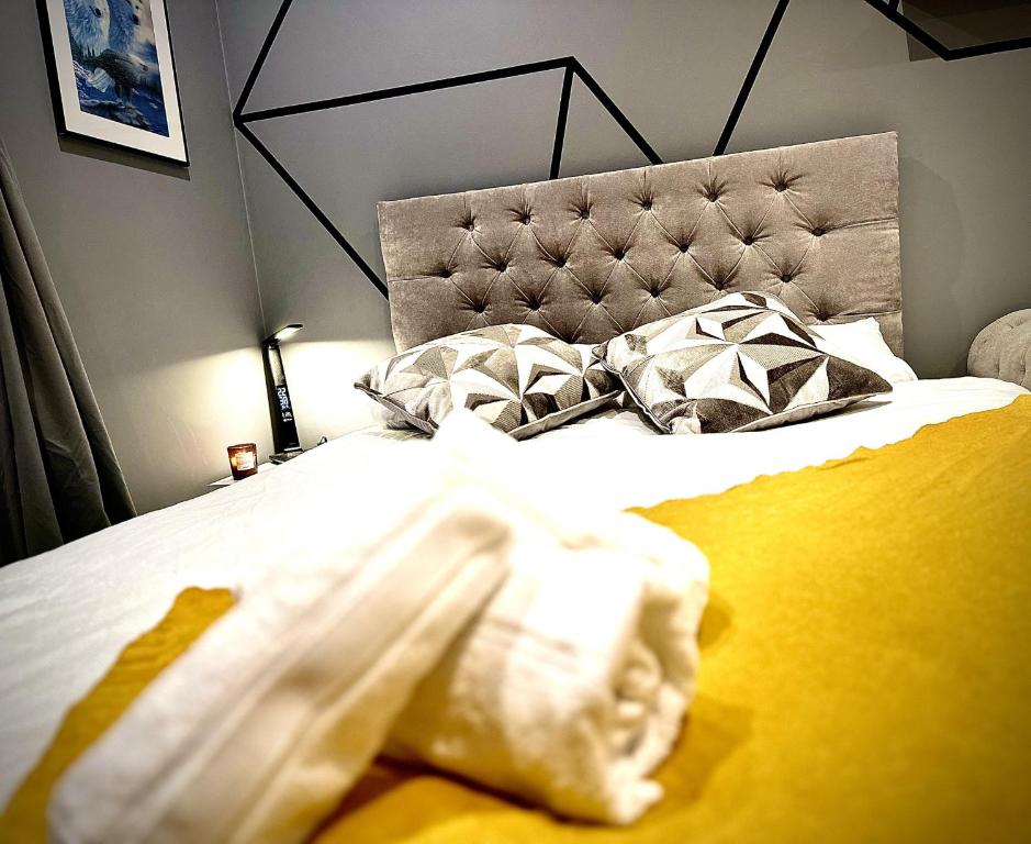 een slaapkamer met een bed met een gele deken en kussens bij Inviting 2-Bed Apartment in South Croydon in Purley