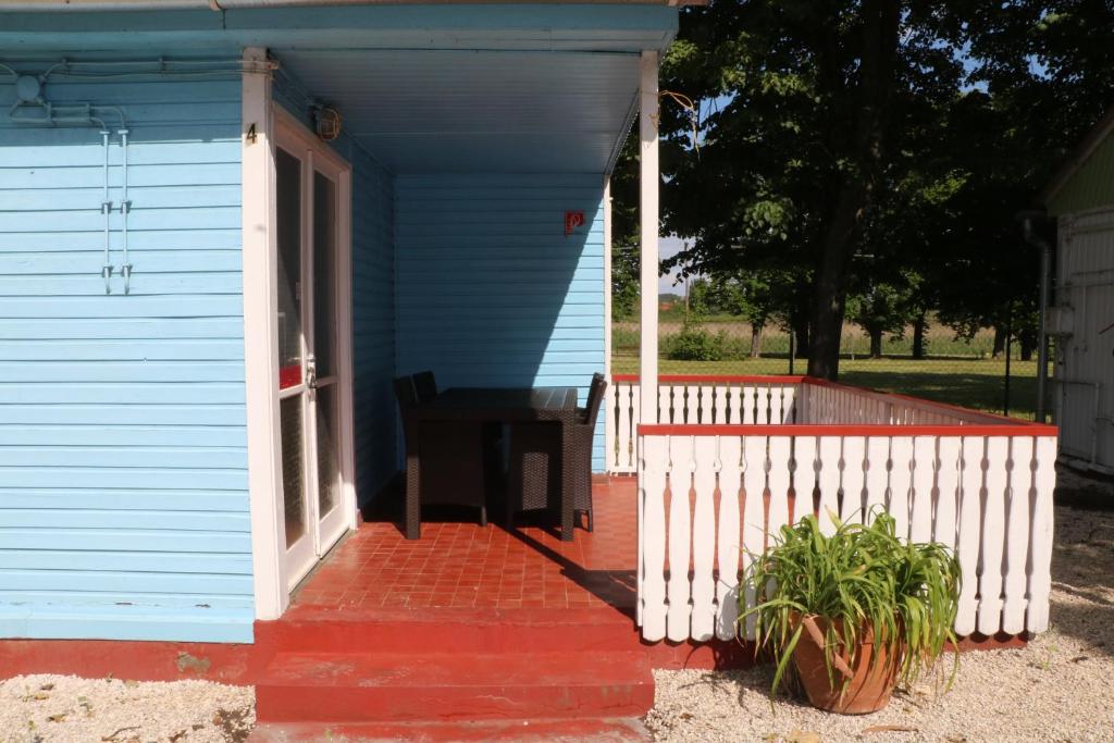 Tulipán Camping في جينيسدياس: البيت الأزرق مع شرفة عليه طاولة