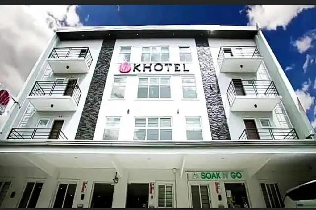 een wit gebouw met een k hotels bord erop bij Khotel Pasay in Manilla