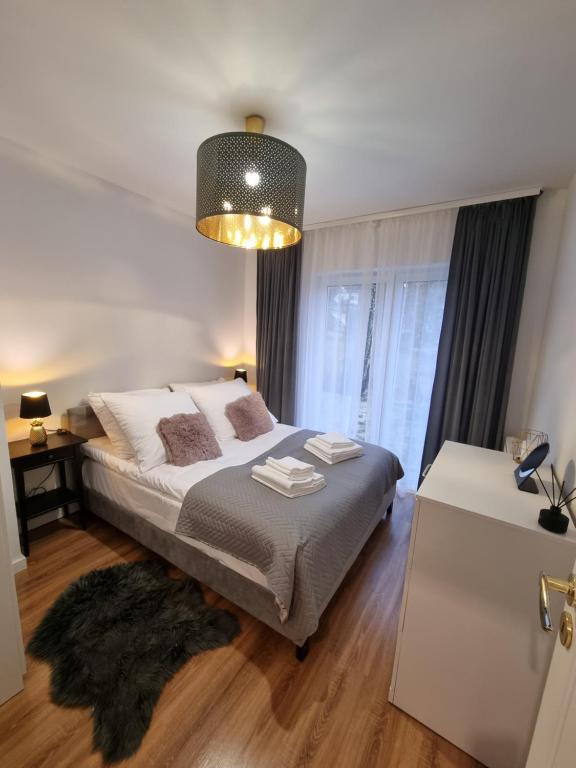 a bedroom with a bed and a large window at Apartamenty Chopina in Karpacz