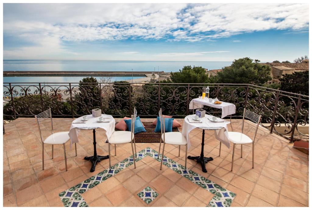 un patio con 2 mesas y sillas en un balcón en Boutique - Lodge & Suites, en Crotone