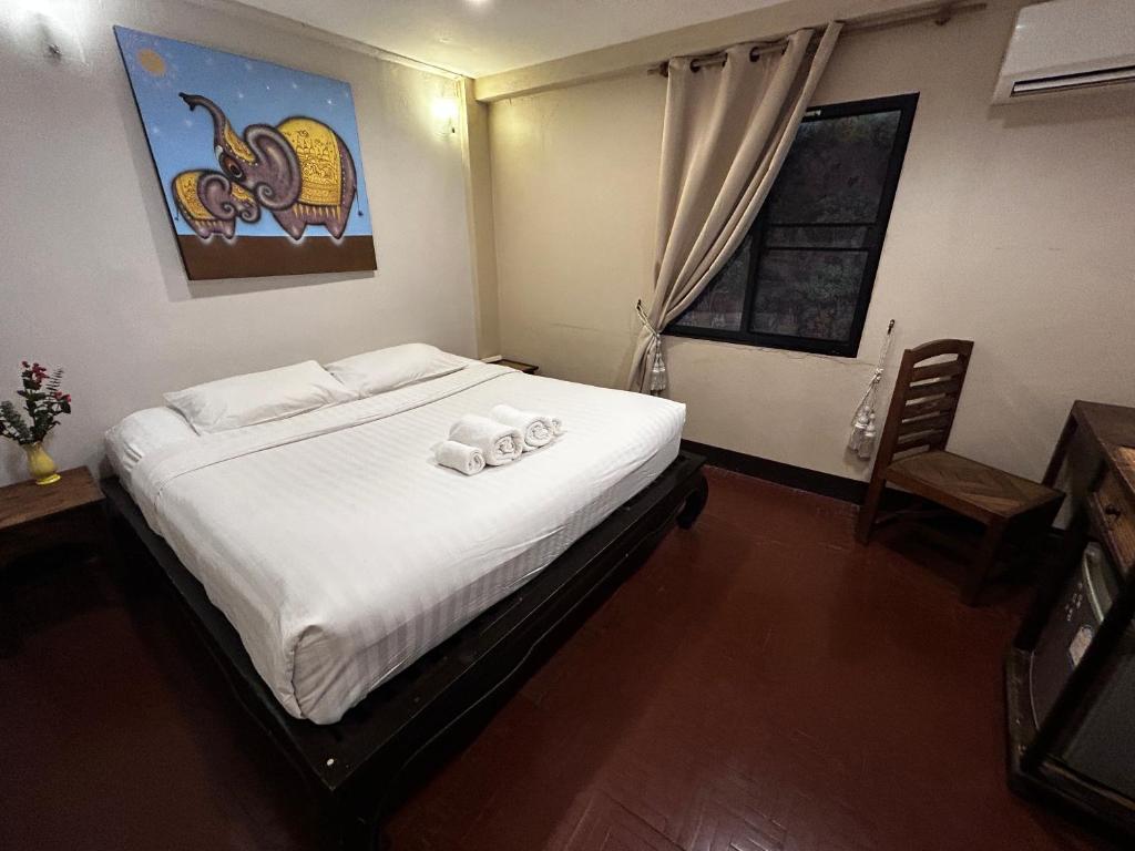 een slaapkamer met een bed met handdoeken erop bij Kamala's Boutique Guesthouse in Chiang Mai