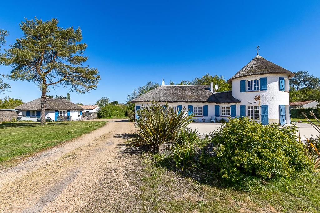 Una gran casa azul y blanca en un camino de tierra en Les gites de Château Trompette, en Le Fenouiller